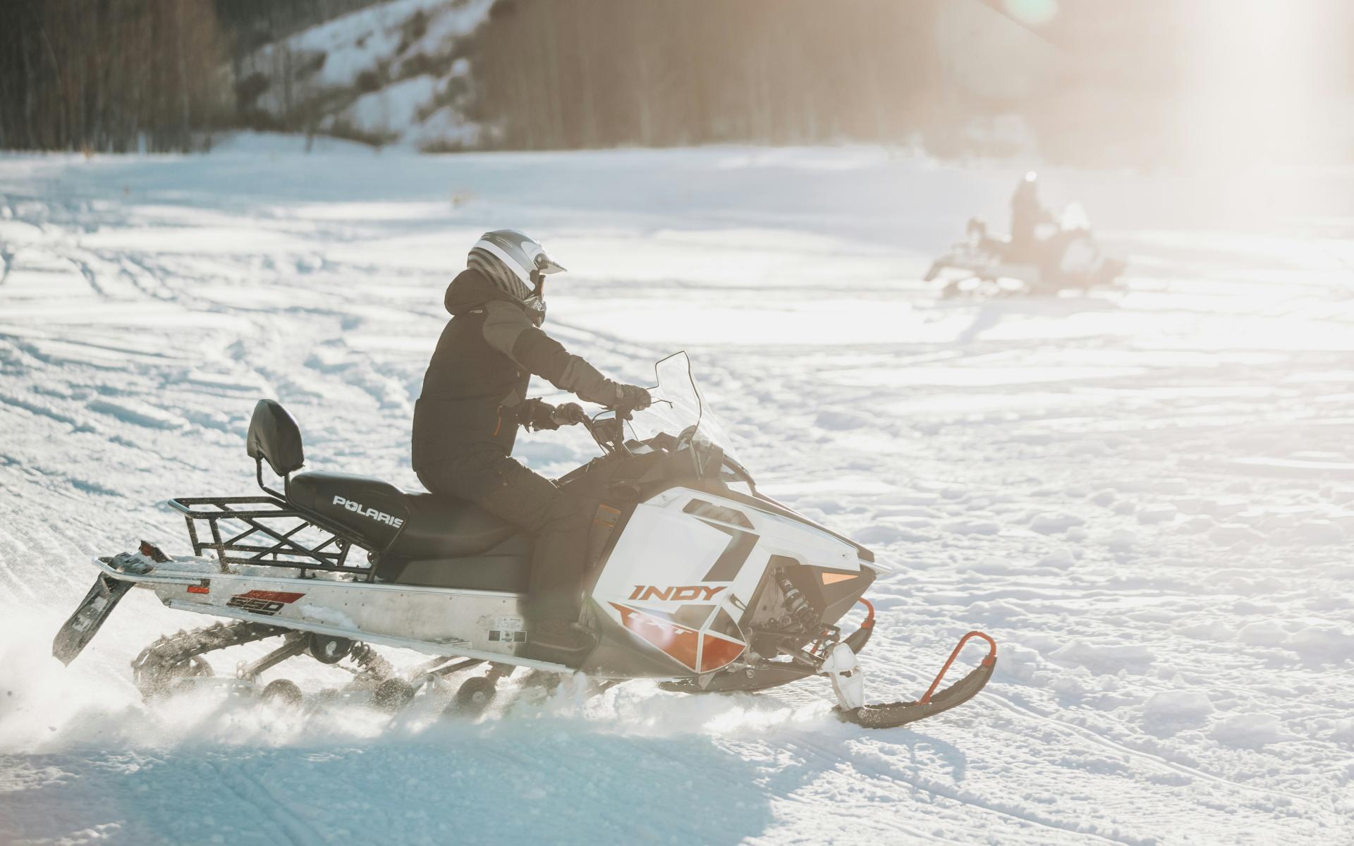 snowmobiler racing through the snow